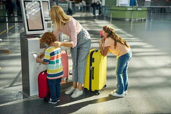 Sohn lernt den Umgang mit einem Selbstbedienungstaschenständer — Stockfoto