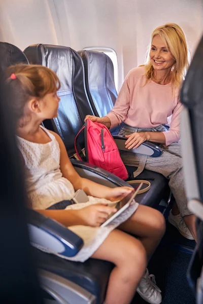 Mujer pasando a una chica su mochila rosa — Foto de Stock