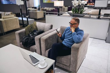 Gözlüklü adam mesaj okuyor.