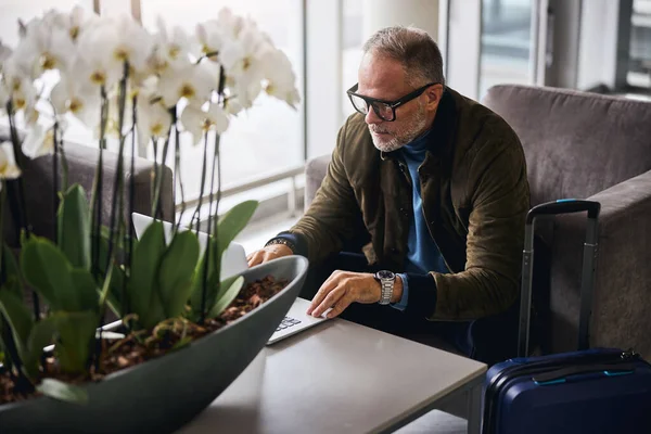 Grauhaariger Mann starrt auf seinen Laptop-Bildschirm — Stockfoto