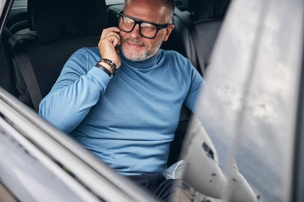 Car passenger with his cellphone looking away — Stock Photo, Image