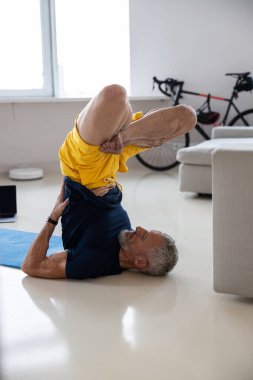 Sporcu egzersiz sırasında bacak bacak üstüne atıyor.