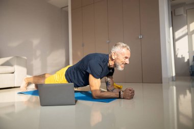 Heyecanlı erkek güneşli bir odada ön tarafı tutuyor.