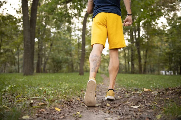 Спортивный человек идет бегать в лес один — стоковое фото