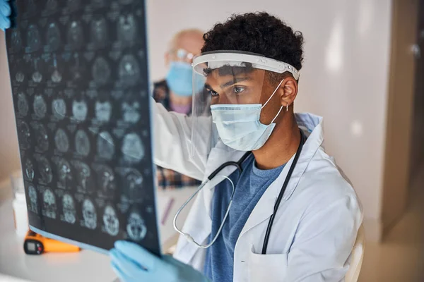 Neurolog stirrar på patientens hjärnbilder — Stockfoto