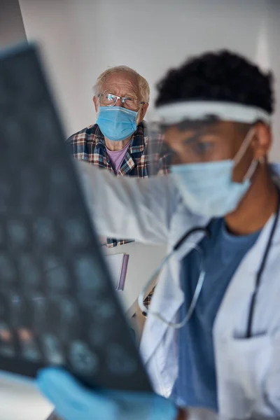 Koncentrerad ung neurolog undersöker sin patient MRT skannar — Stockfoto