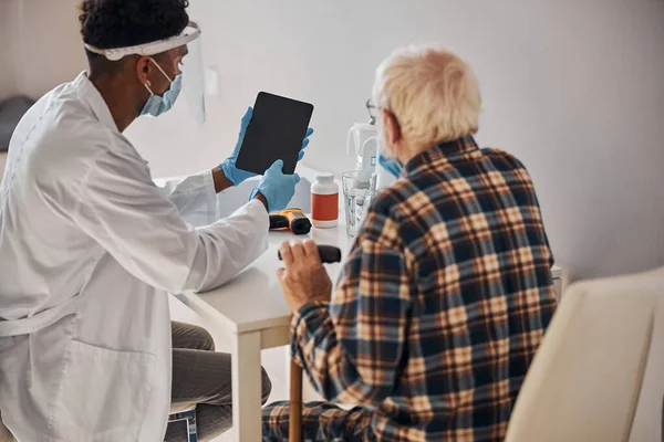 Arzt und Patient beim Blick auf den Tablet-Computer — Stockfoto