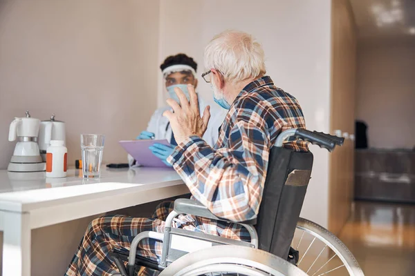 Kıdemli hasta durumunu değerlendiren dikkatli bir doktor. — Stok fotoğraf