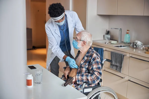 Médico jovem experiente realizando a ausculta cardíaca — Fotografia de Stock