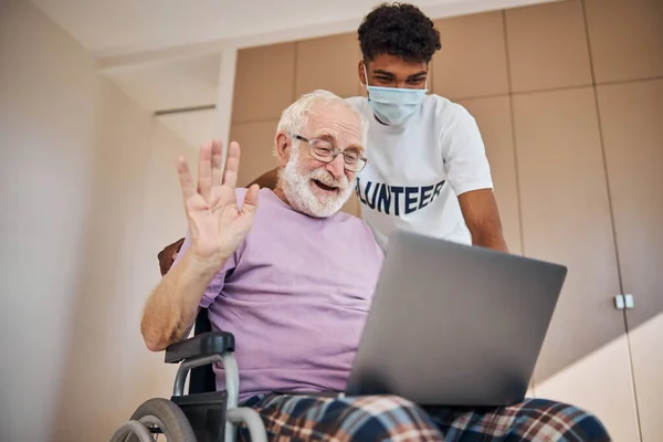 Feliz anciano saludando a su amigo a través de Skype — Foto de Stock