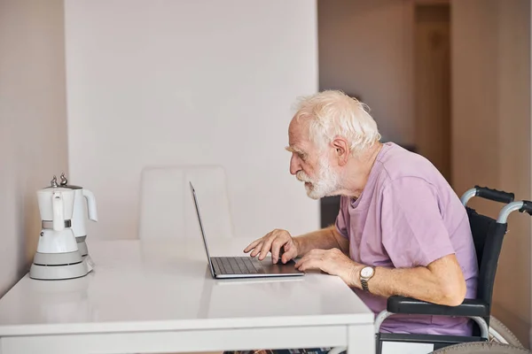 Pensionista masculino escribiendo un correo electrónico en su computadora — Foto de Stock
