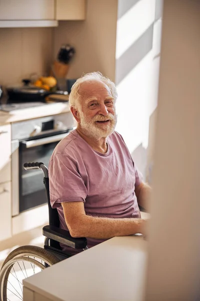 Nöjd skäggig äldre man vid bordet — Stockfoto