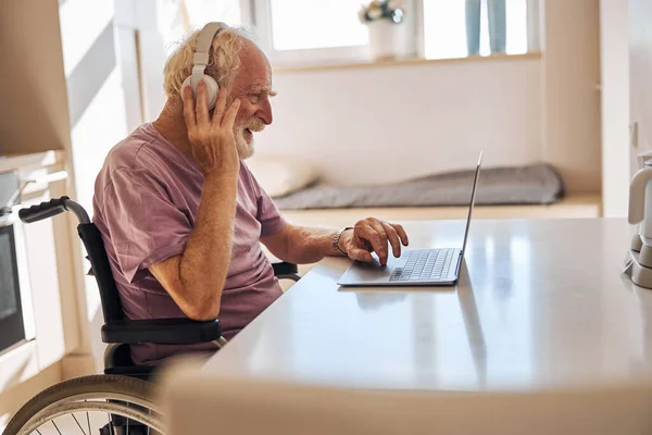 Homem com deficiência a trabalhar no seu computador portátil — Fotografia de Stock