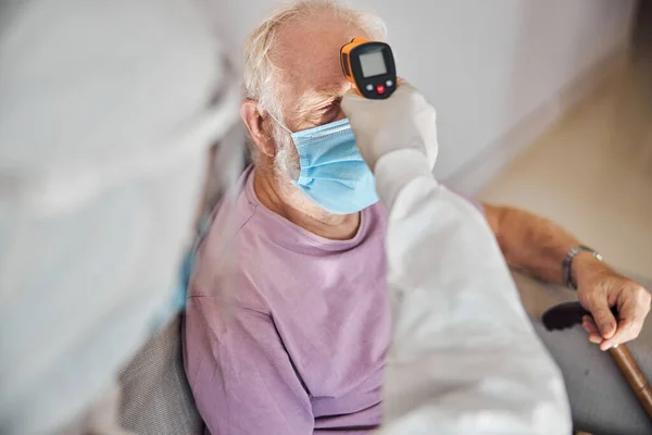 Doctor usando un termómetro infrarrojo para la medición de la temperatura — Foto de Stock
