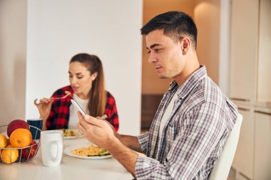 Mutfak masasında oturan evli çift.