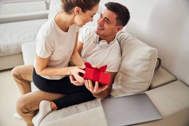 Eşi hediyeyi mutlu eşine veriyor.