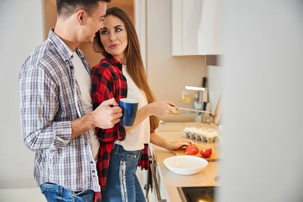 Uomo con una tazza di caffè sorridente a sua moglie — Foto Stock