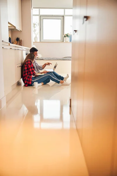 Uomo allegro mostrando qualcosa a sua moglie sul suo computer portatile — Foto Stock