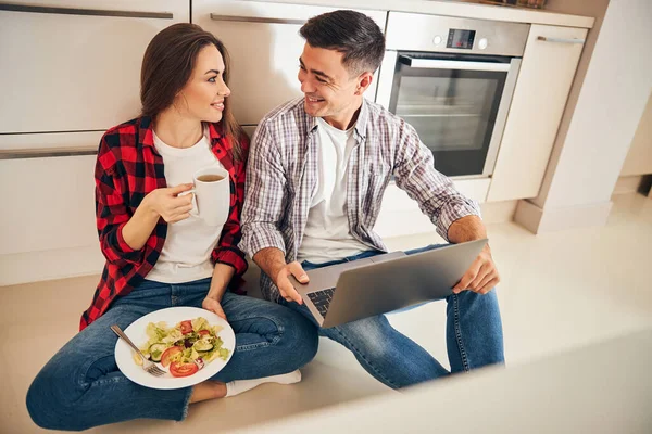 Szczęśliwa para siedzi na podłodze w kuchni — Zdjęcie stockowe