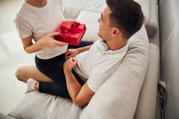 Νεαρός σύζυγος λαμβάνει το δώρο από τη σύζυγό του — Φωτογραφία Αρχείου