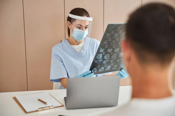 Jovem assistente de clínica médica olhando para a imagem de raio-x — Fotografia de Stock