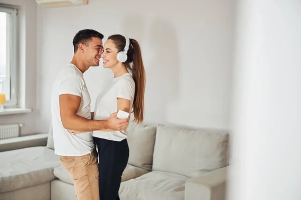 Encantadora pareja escuchando música juntos en casa —  Fotos de Stock