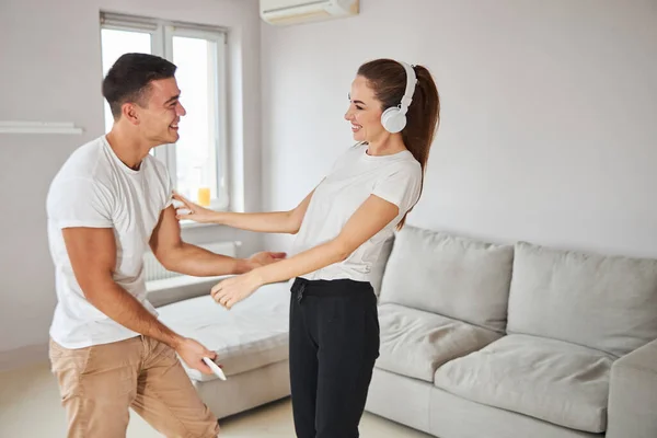 Young boyfriend and girlfriend dancing to music at home — Stock Photo, Image