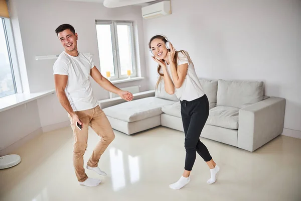 Handsome gentleman and his lady enjoying music at home — Stock Photo, Image