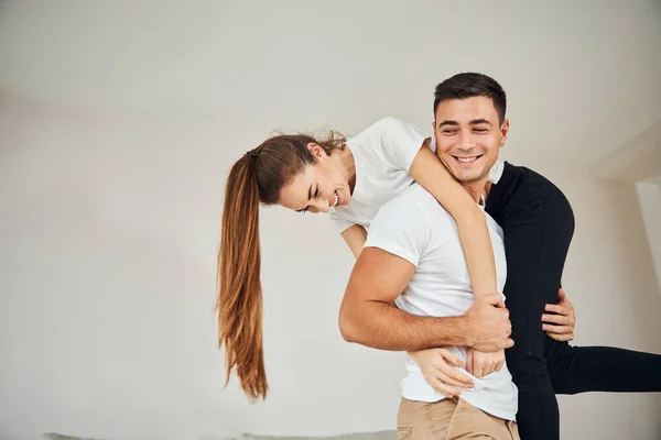 Strong gentleman holding his beauitful woman on his back — Stock Photo, Image