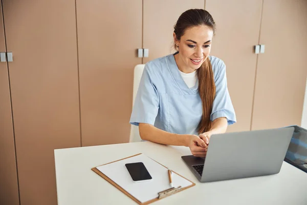 Médico profesional femenino trabajando en su portátil —  Fotos de Stock