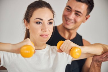 Yakışıklı adam ona bakarken güzel bayan spor yapıyor.