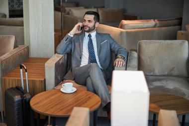 Akıllı telefondan konuşan kendine güvenen bir işletmeci.