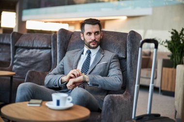 Profesyonel iş adamı saatini kuruyor.