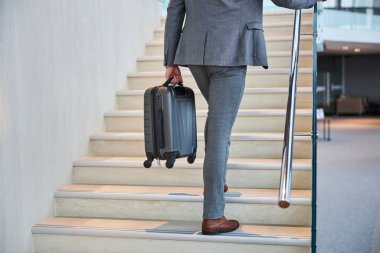 Merdivenlerde yürüyen ve raylara tutunan biri.