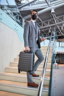 Profesyonel iş adamı merdivenlerin ortasında duruyor.