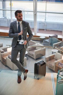 Kahveli yakışıklı genç adam telefonunu bir kenara koyuyor.