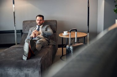 Ayrılma odasındaki zamanını ayarlayan dakik bir adam.