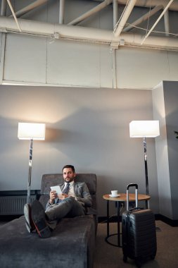 Tabletle yatakta uzanan bir iş adamı.