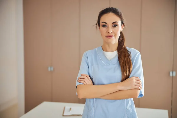 Giovane bella signora in uniforme medica in posa in ufficio — Foto Stock