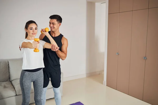 Fitness-consciente sorrindo casal fazendo exercícios em casa juntos — Fotografia de Stock