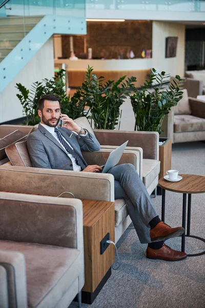 Businessman making a phone call in a waiting room — Stock Photo, Image