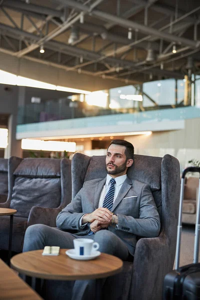 Adam bileğindeki saati ayarlıyor.