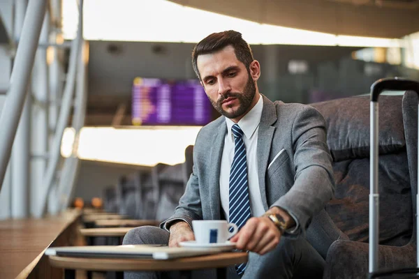 Oficial de negocios que busca una taza de café en una mesa — Foto de Stock