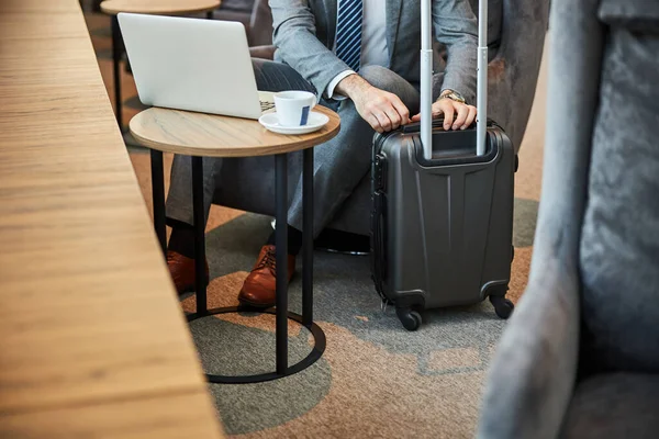 Man opent zijn zwarte bagage op wielen. — Stockfoto