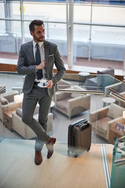 Schöner junger Mann mit Kaffee, der sein Handy beiseite legt — Stockfoto