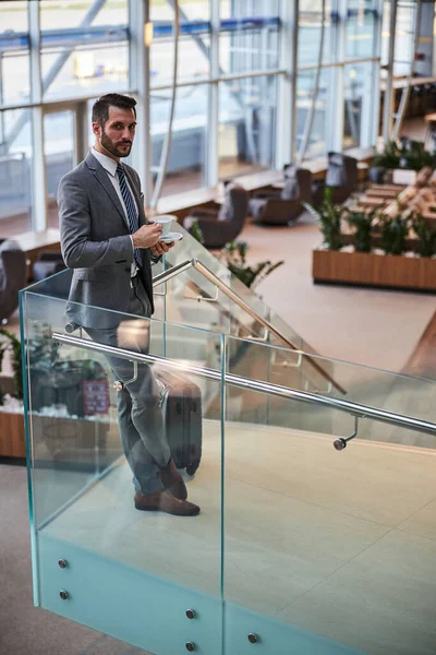 Businessman having a coffee break at the airport — Stock Photo, Image