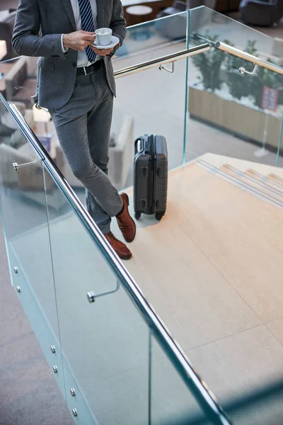 Entrepreneur with coffee throwing one leg over the other — Stock Photo, Image