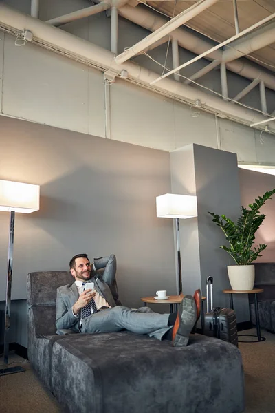 Excited business official relaxing on a waiting room bed — Stock Photo, Image