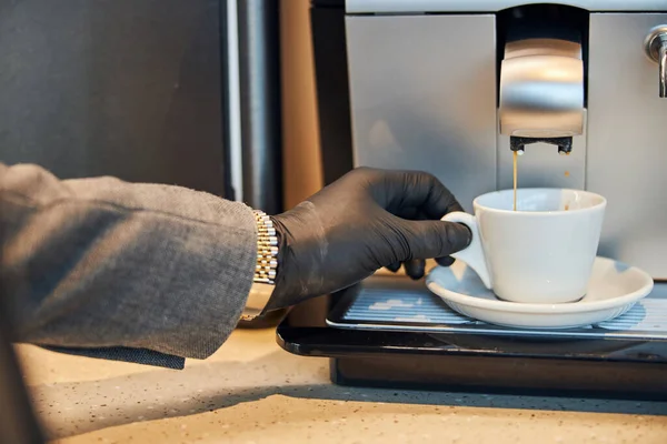 Café derramando em uma xícara branca de uma máquina de café expresso — Fotografia de Stock