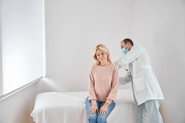Nörolog kadın hastanın paraspinal kaslarını elle yokluyor. — Stok fotoğraf